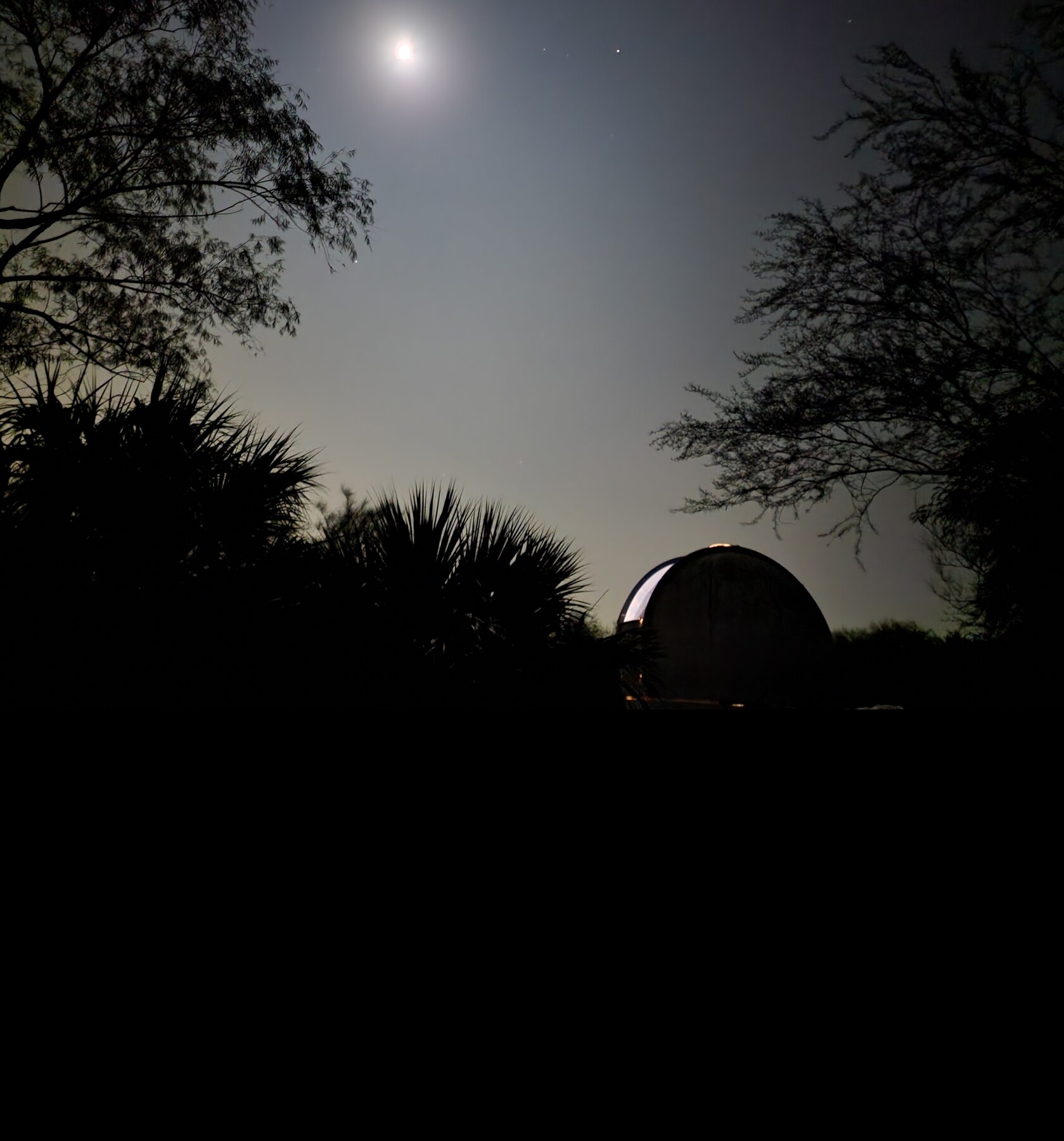 An observatory dome silhouetted against the night sky